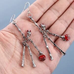 Trick-or-treating skeleton girl earrings carrying a pumpkin. Movable limbs